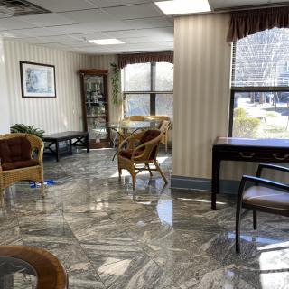 A well-lit waiting room with comfortable seating and large windows.
