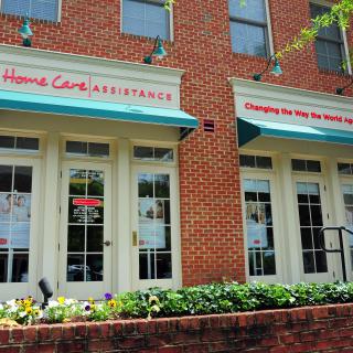 A brick building with a storefront that offers home care assistance services.