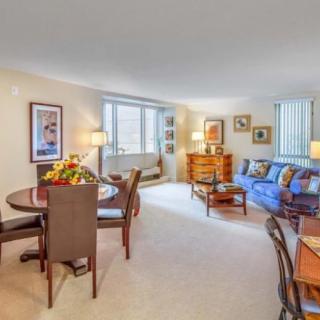 A bright and cozy living room with an adjacent dining area featuring comfortable furniture and decorative elements.