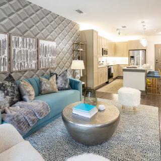 A modern and cozy living room with an open floor plan leading to the kitchen.