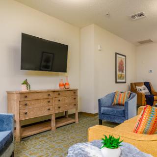 A cozy living room setup featuring a television, comfortable seating, and decorative elements.