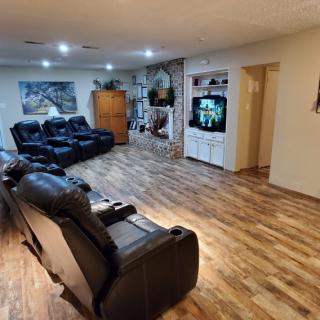 A spacious living room with comfortable recliner chairs and a home theater setup.