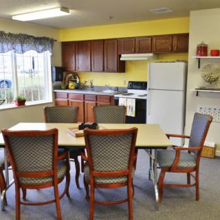 A cozy kitchen and dining area with a table, chairs, and basic appliances.