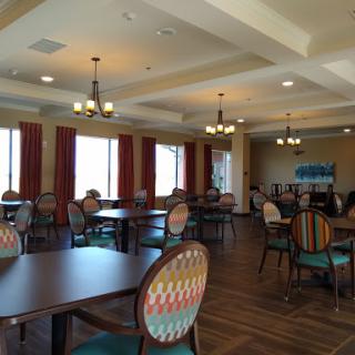 A spacious dining area with decorative chairs and ambient lighting, creating a warm atmosphere.