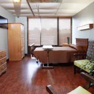 A cozy hospital room with a patient bed and comfortable furnishings.