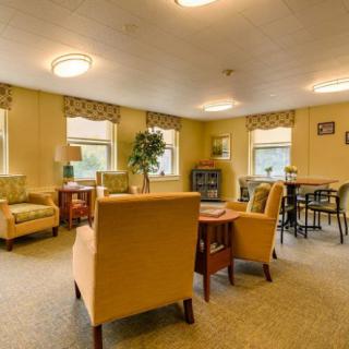 A cozy living room with comfortable seating and natural light from multiple windows.