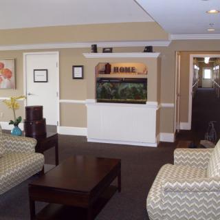 A cozy living room featuring an aquarium, stylish furniture, and warm decor.