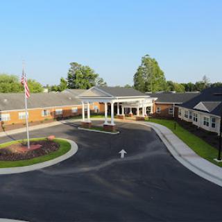 Aerial view of a community center featuring well-manicured landscaping and a clear blue sky.