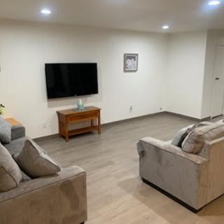 A minimalist living room with comfortable sofas and a wall-mounted television.