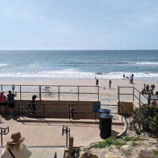 A scenic view of the beach with people enjoying the ocean waves.