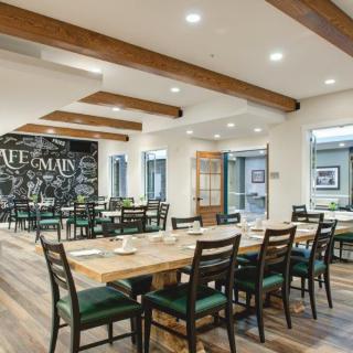 A modern restaurant dining area featuring wooden beams and neatly arranged tables and chairs.