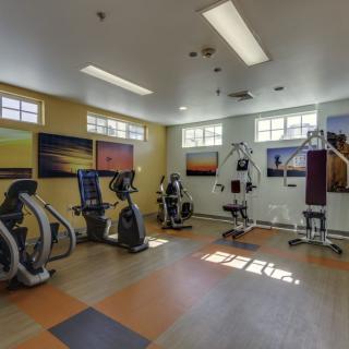 A well-equipped gym with various exercise machines in a bright, welcoming space.