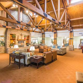 A spacious lodge interior featuring wooden beams and comfortable seating areas.