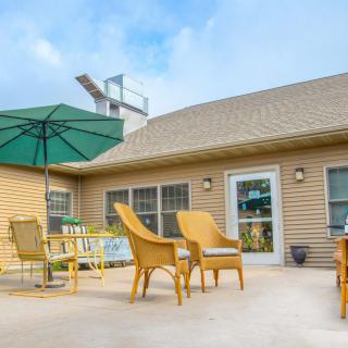 A cozy patio area with outdoor furniture and an umbrella on a sunny day.