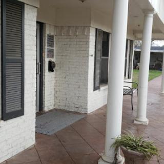 A welcoming entrance featuring a white brick exterior and a porch with columns.