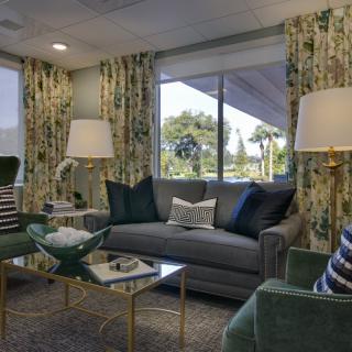 A cozy living room with elegant furniture, featuring a sofa, armchairs, and decorative elements.