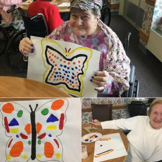 Elderly individuals enjoying a creative painting session, showcasing colorful butterfly artworks.