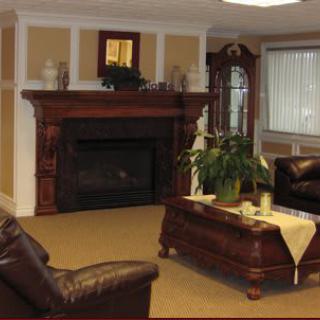 A cozy living room featuring a fireplace, leather couches, and a wooden coffee table with decorative plants.