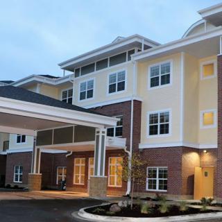A modern residential building with multiple stories and a covered entrance.