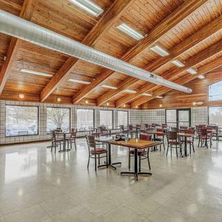 A spacious modern dining area with wooden ceilings and large windows.