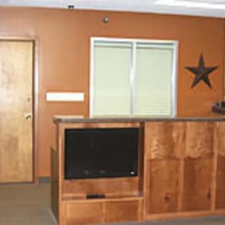A reception area featuring wooden furniture, a mounted TV, and a star decoration on the wall.