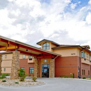 Modern hotel building with an inviting entrance and cloudy sky backdrop.