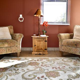A cozy living room setup featuring patterned chairs, a warm lamp, and a decorative rug.