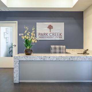 A modern reception desk at Park Creek featuring a floral arrangement and stylish decor.