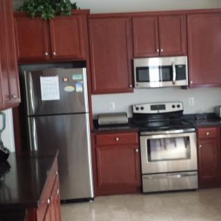 A modern kitchen with stainless steel appliances and wooden cabinets.
