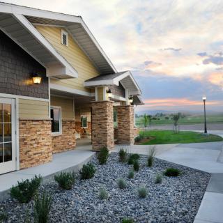 A beautifully designed modern house at sunset, showcasing a blend of stone and wood elements.