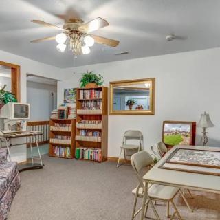 A cozy home office with a bookshelf, computer, and study area.