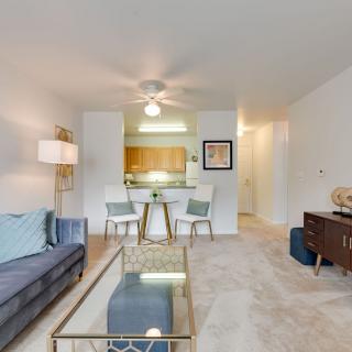 A modern apartment living room with a comfortable sofa and an open dining area.