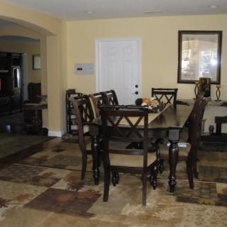 A dining room featuring a dark wooden table with matching chairs and neutral-colored walls.