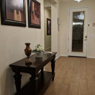 A beautifully decorated hallway featuring a console table with a vase and framed art on the walls.