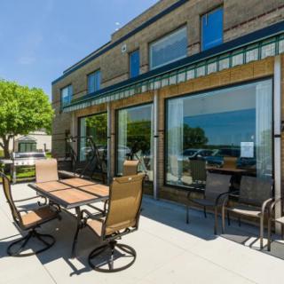 A sunny outdoor patio with tables and chairs in front of a modern building.