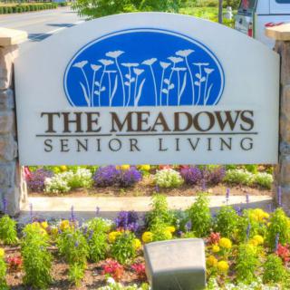 The Meadows Senior Living entrance sign with colorful landscaping.