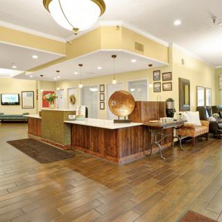 A spacious lobby with a wooden reception desk, stylish decor, and comfortable seating.