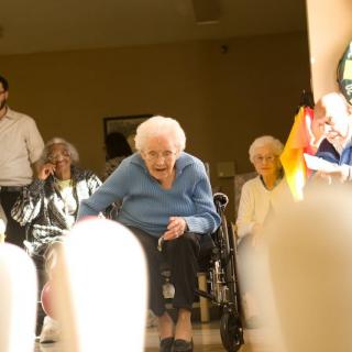 Elderly individuals participating in a fun bowling activity at a nursing home.