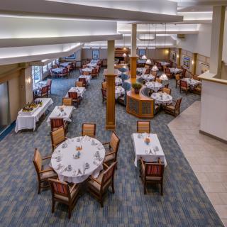 An empty restaurant dining area with neatly arranged tables and chairs.