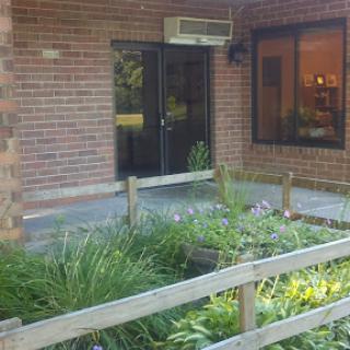 Entrance to a brick building surrounded by green landscaping.