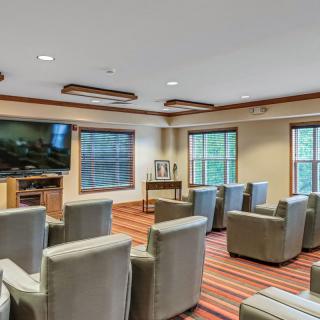 A cozy theater room with comfortable seating and a large television.