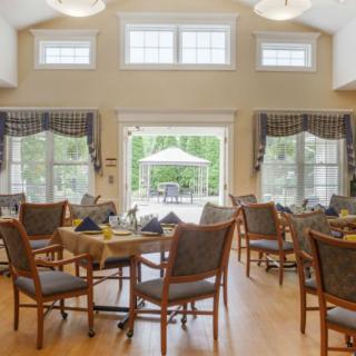 A bright and inviting dining area with neatly arranged tables and large windows letting in natural light.