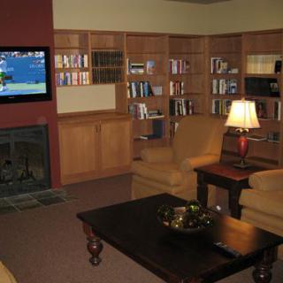 A cozy living room with bookshelves, a television, and comfortable seating.