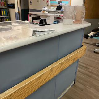A reception desk featuring a wooden barrier and various office supplies.