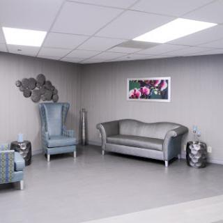 A modern waiting area featuring stylish gray furniture and decorative wall art.