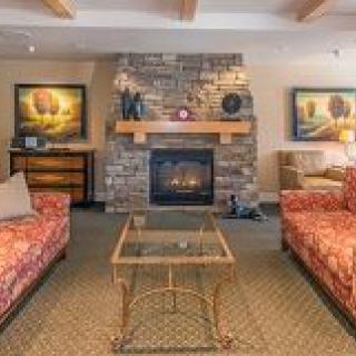 Cozy living room with a stone fireplace and red patterned sofas.