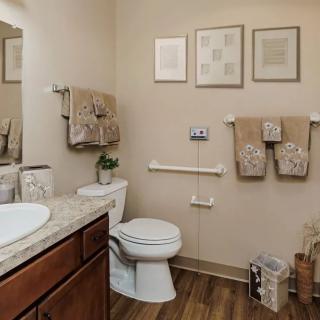A well-decorated bathroom with a toilet, sink, and towels organized neatly.