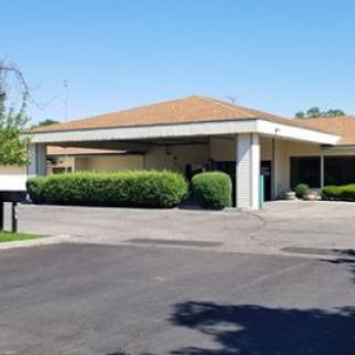 A well-maintained residential building with a landscaped front yard.