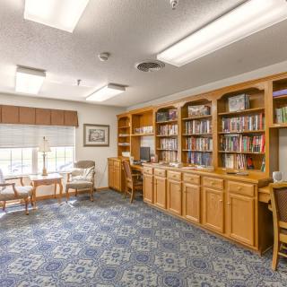 A quiet library space with bookshelves, seating, and natural light.