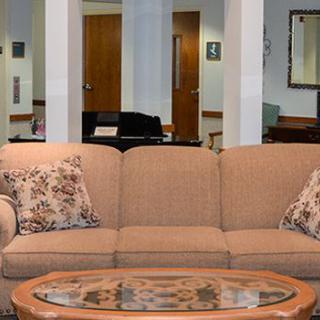 A cozy living room with a beige sofa adorned with patterned cushions and a wooden coffee table.